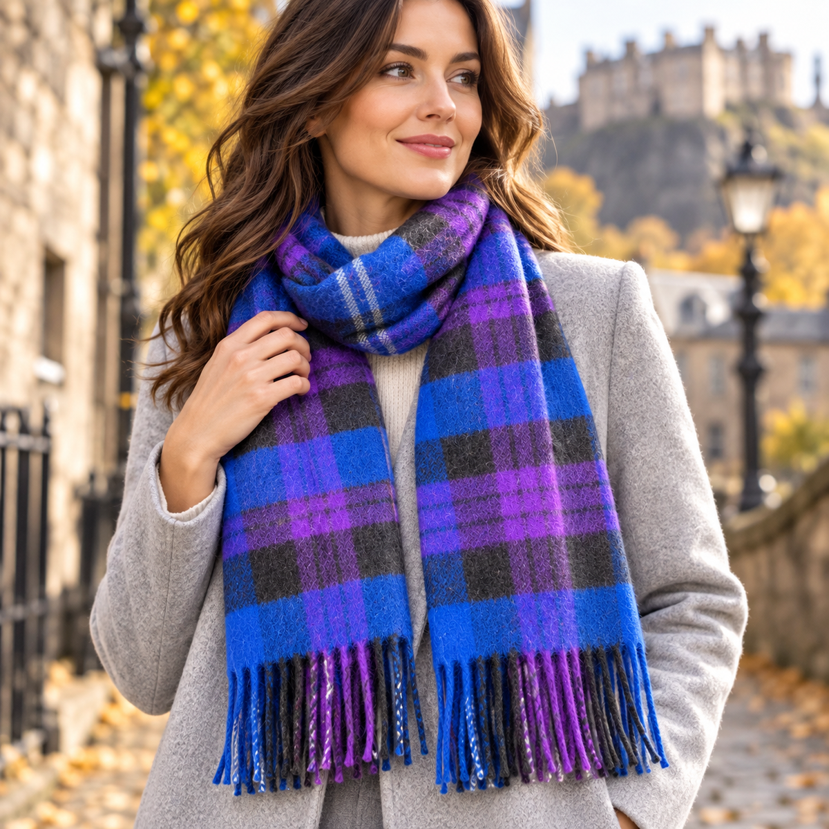Woman wearing a Fraser Scott blue and purple tartan lambswool scarf outdoors on a historic Edinburgh street