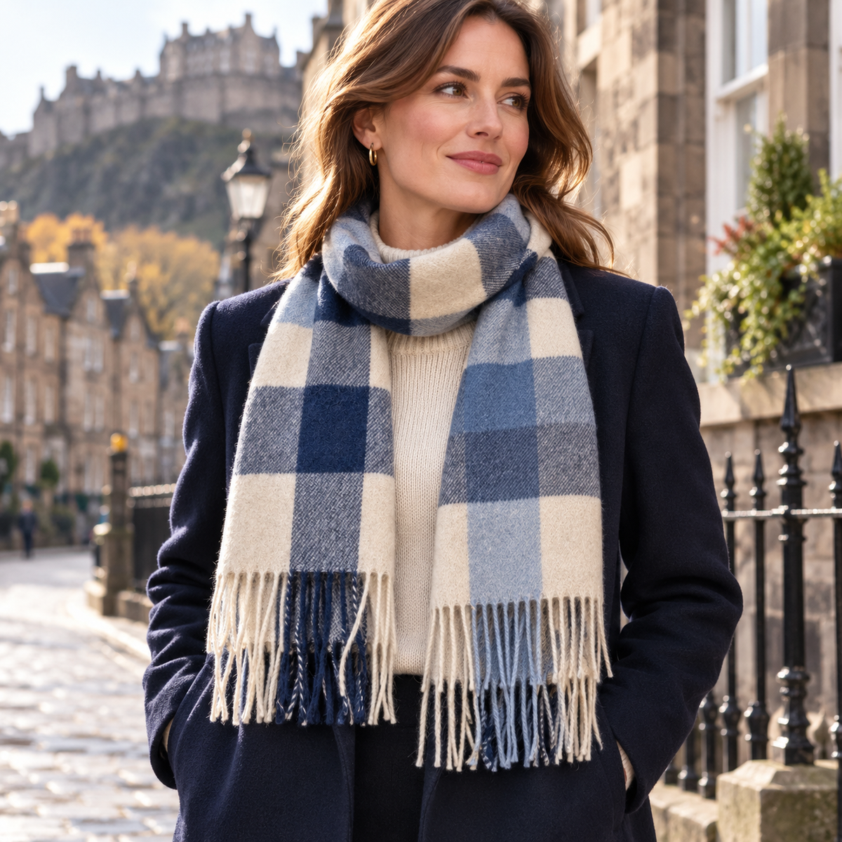     Woman wearing The House of Balmoral Blue Beige Square lambswool scarf with a navy winter coat