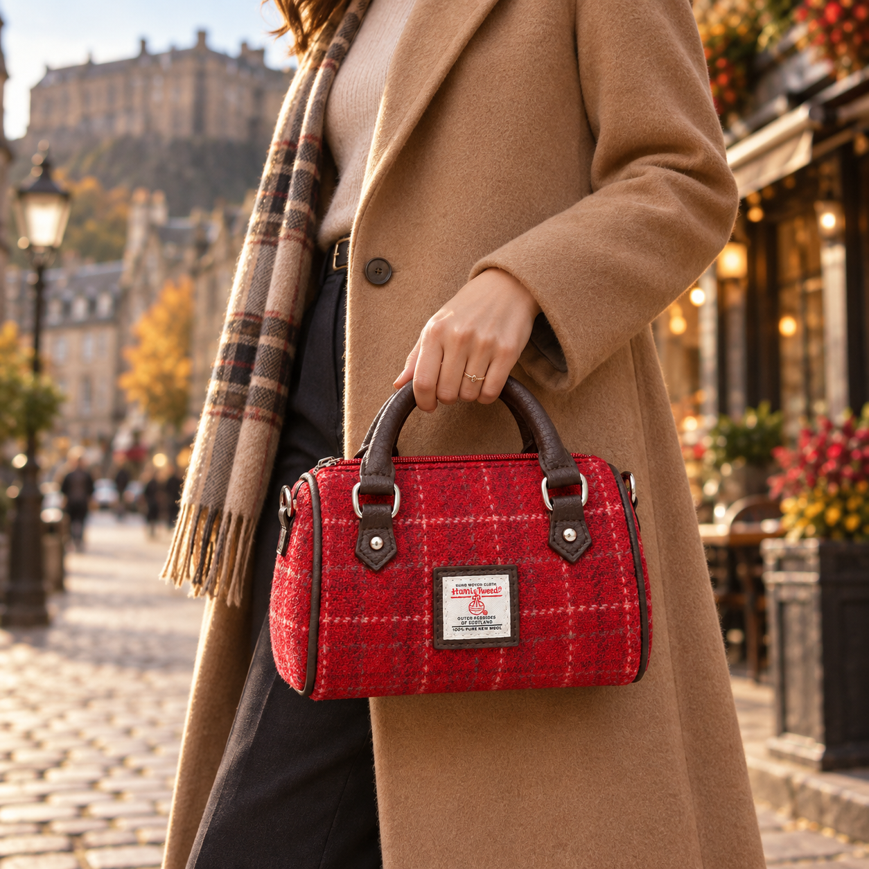 Woman carrying a red Harris Tweed mini handbag with brown handle on an autumn street in Edinburgh